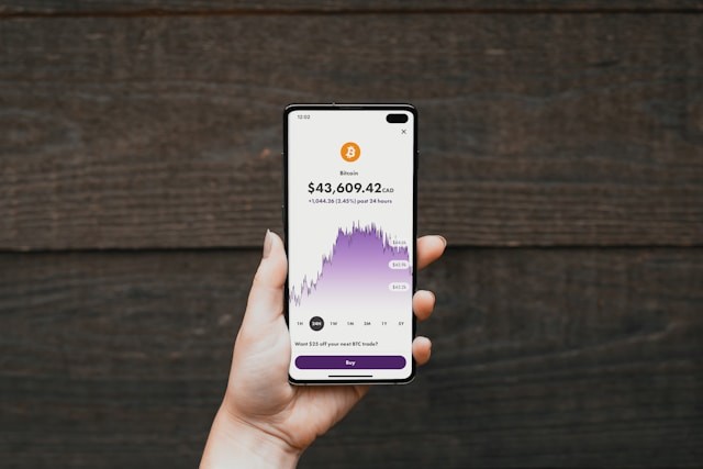 person holding phone with trading app